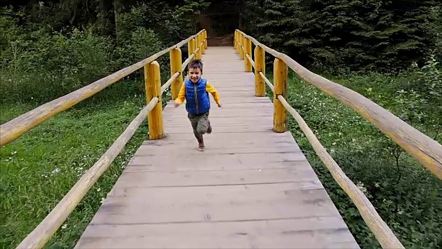 快乐的男孩跑着奔过桥视频素材