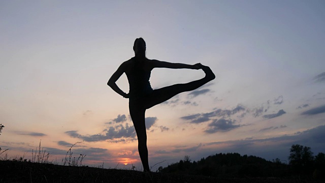 日落时分，一个年轻女子在练习瑜伽视频素材