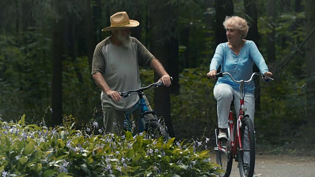 公园里一对骑着自行车的可爱老夫妇视频素材