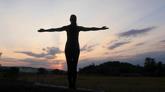 日落时分，一个年轻女子在练习瑜伽视频素材