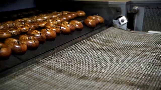 在面包房的工厂里制作新鲜又热又美味的百吉饼:百吉饼从烤箱里出来视频素材