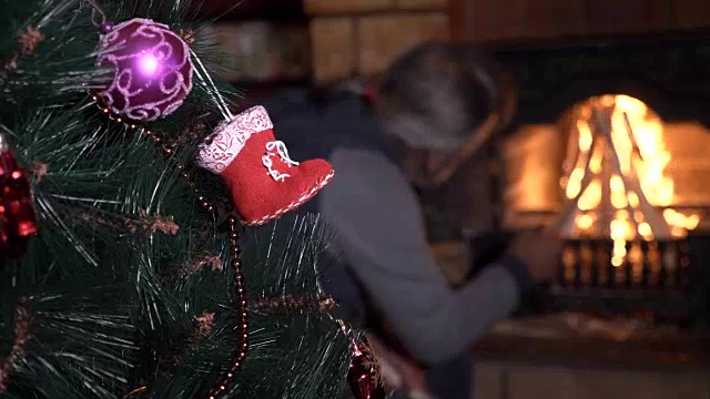 装饰圣诞树与高级男子在壁炉附近的背景视频素材
