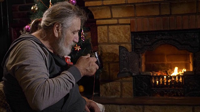 圣诞夜，老人在壁炉边喝茶视频素材