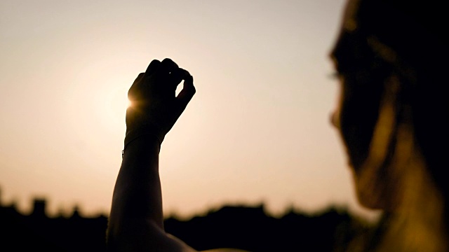 独自站在田野里的女人拼命想在日落时抓住太阳，但她不能，令人惊叹的景色视频下载