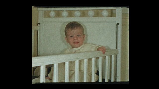 肖像和可爱的小男孩谁学会爬进他的婴儿床视频素材