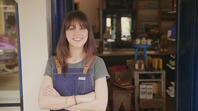 微笑的熟食店老板双臂交叉站在店外的肖像视频素材