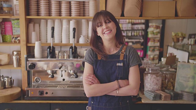 微笑的小企业主在咖啡店双臂交叉站着视频素材