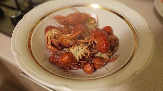 女性摊开一盘红煮小龙虾。新鲜的海产在家里煮熟就可以吃了。晚餐在度假。视频下载