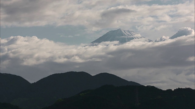 长镜头:日本静冈县，富士山的顶峰在云层的空隙中可见视频素材