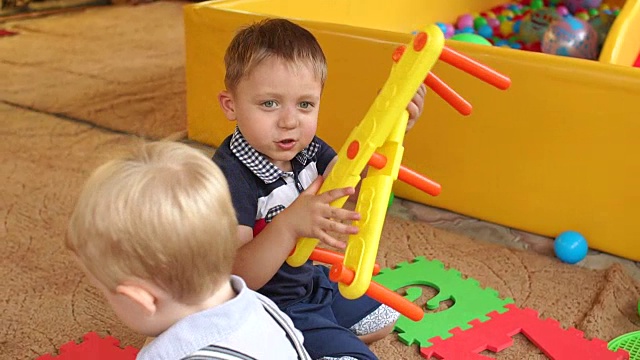 有趣的男孩在幼儿园玩玩具，慢动作视频下载