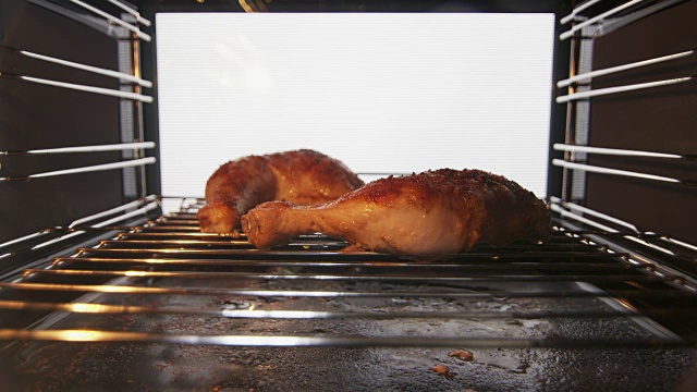 烤鸡腿在烤箱里烧。鸡肉呈棕色，酥脆。视频下载