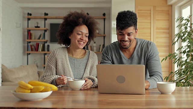 年轻的非洲裔美国夫妇有乐趣，而上网在笔记本电脑。视频素材