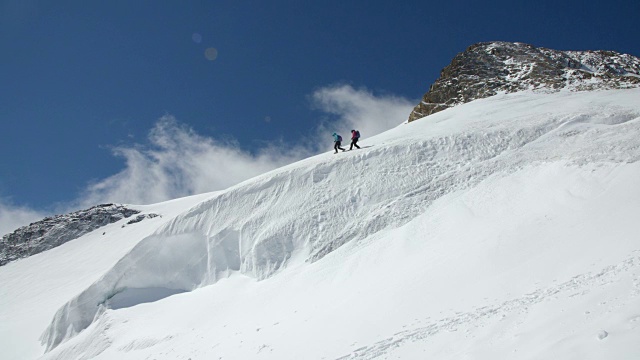 两名女登山队员在穿越冰川时脚底稳固，险峻地跌落。视频素材
