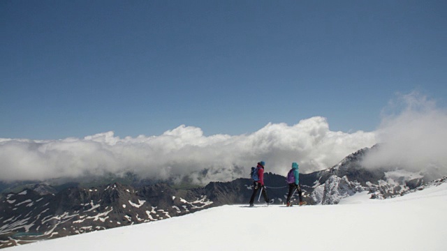 为了安全，两名女登山队员用绳子系在一起，徒步穿越冰川。视频素材
