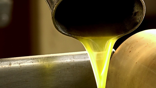 特写镜头的纯特级初榨橄榄油落入钢罐:油磨视频下载