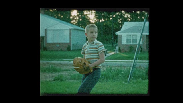 1960年在郊区后院玩棒球的小男孩视频素材
