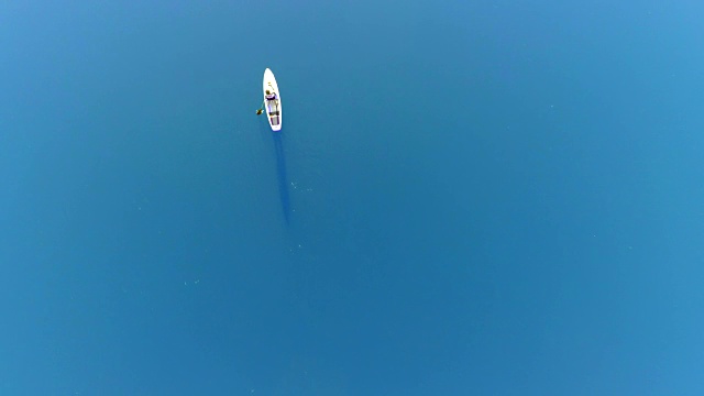 空中女子站立划桨登机在蓝色的海上视频素材