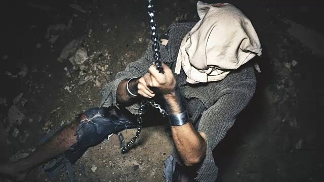 一个带着铁链的囚犯被关在地下室里，只有一点光线透进来视频下载
