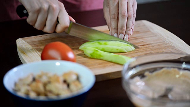 女人切黄瓜。女手切绿黄瓜环。视频素材