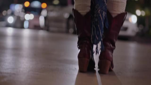 年轻女子走和跳在牛仔靴子在拉斯维加斯strip晚上。视频下载