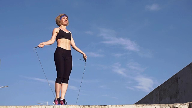 健身女孩在户外用跳绳做运动，慢动作视频下载