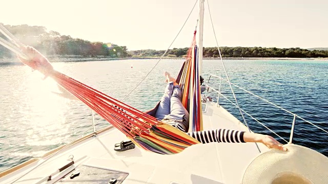 一个女人躺在一艘帆船的吊床上视频素材