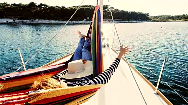 在帆船上的吊床上休息的女人视频素材