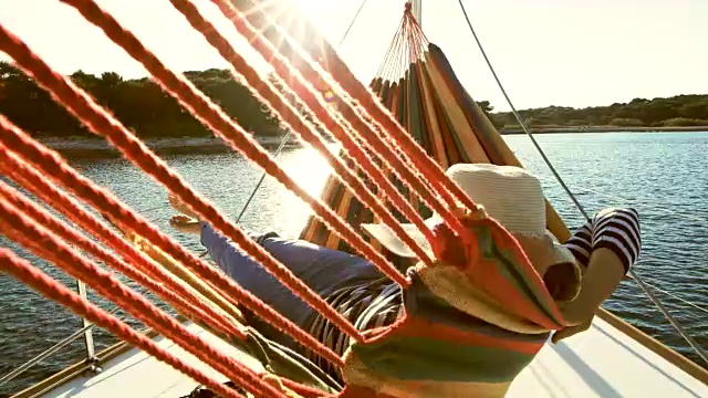 女士躺在一艘帆船的吊床上视频素材