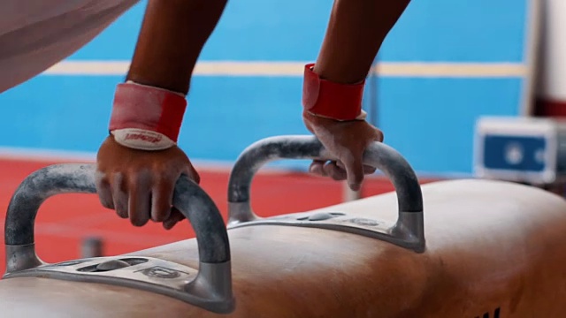强壮的体操运动员在鞍马上摇摆双腿视频下载