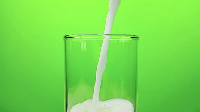鲜白牛奶倒入杯中，色键绿色画面背景，慢镜头拍摄，饮食和健康营养视频素材