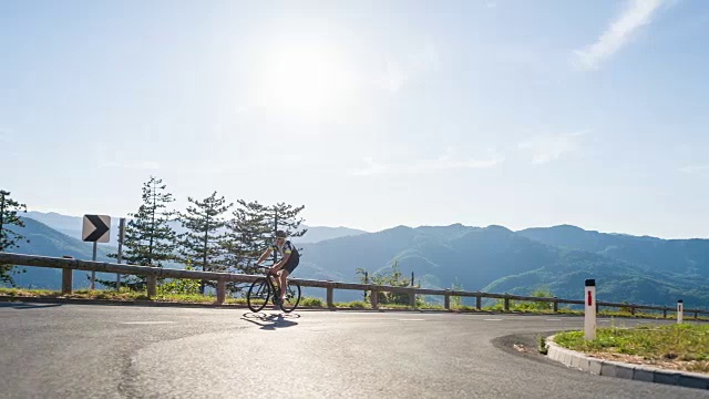 一名年轻的男性骑着自行车奋力向山顶进发视频素材