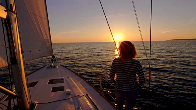女人在帆船上欣赏美丽的日落视频素材