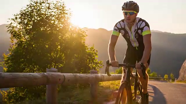 在日落时分骑自行车上山的人视频素材
