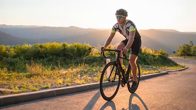 日落时分在山口上骑公路自行车视频下载