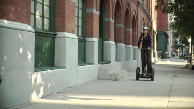 在美国纽约翠贝卡的人行道上骑着赛格威的女人视频下载