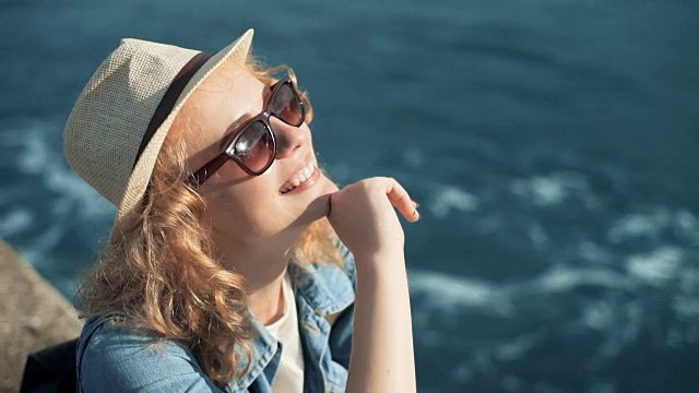 微笑的女人在海滩上戴着白色的太阳帽享受夏天的阳光视频下载