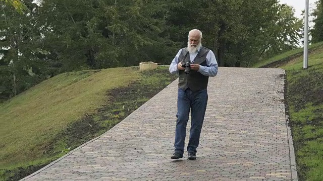 老人在公园里拍了一张大自然的照片视频素材