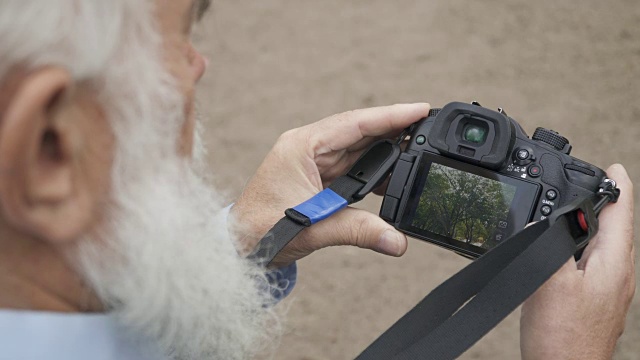 老人在相机里看着一张照片视频素材