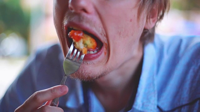 在模糊的背景下，大胡子男子正在咀嚼快餐、中国面食和蔬菜。1920 x1080视频下载