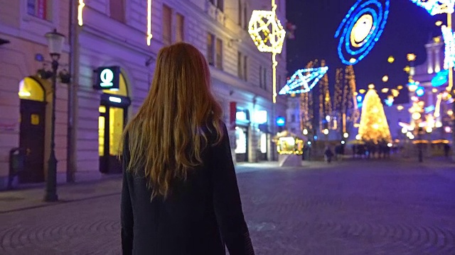 一个女人在广场上走向圣诞树视频素材