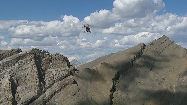 直升机飞过崎岖的山脉视频素材