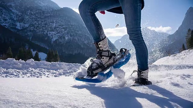 年轻女子在山腰穿雪鞋视频素材