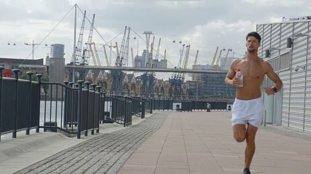 一个年轻人跑过伦敦，后面跟着伦敦城。视频素材