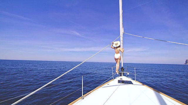 穿着泳衣的女人在帆船上欣赏风景视频素材