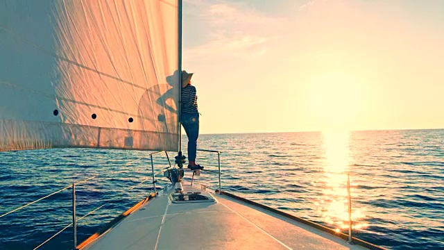 女人从一艘帆船的船头观察日落视频下载