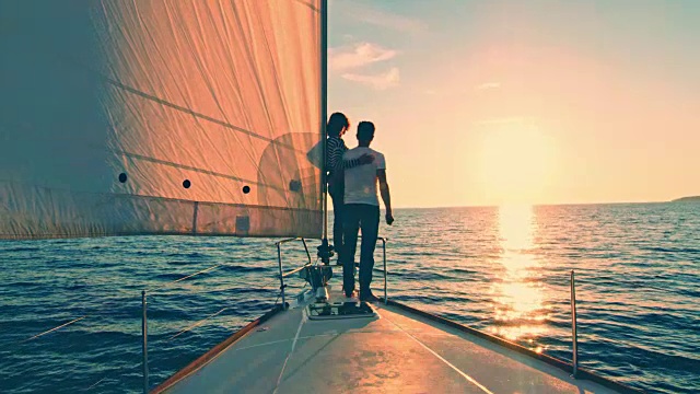 一对情侣在海上航行时欣赏日落视频素材