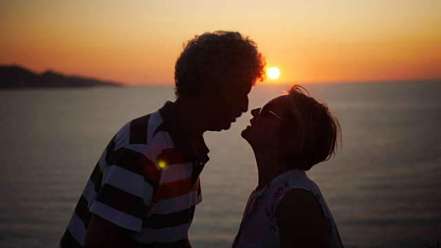 一对浪漫的老年情侣在夕阳下接吻视频素材