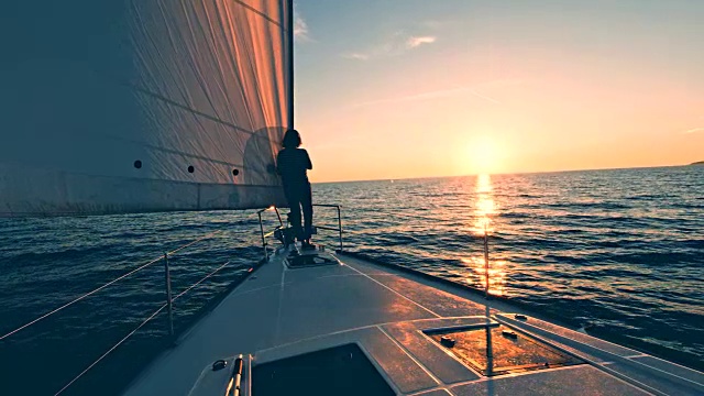 日落时分，一名女子从帆船上走下来视频素材