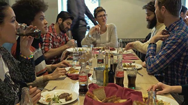一大群快乐的朋友在餐厅吃午餐并交流。视频素材