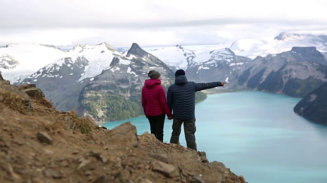 一对夫妻站在山顶上看风景视频素材